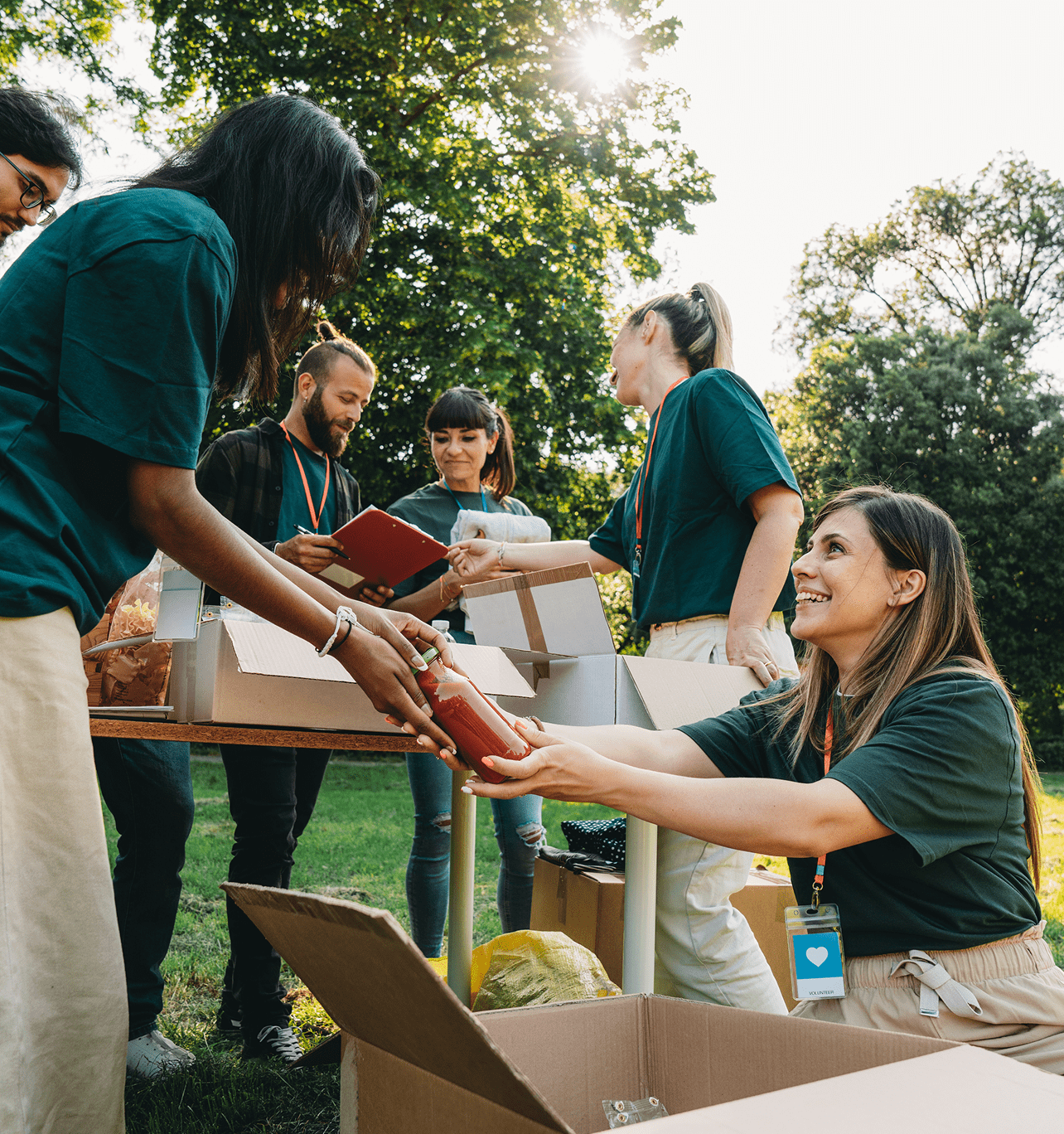 Group packing boxes in park setting